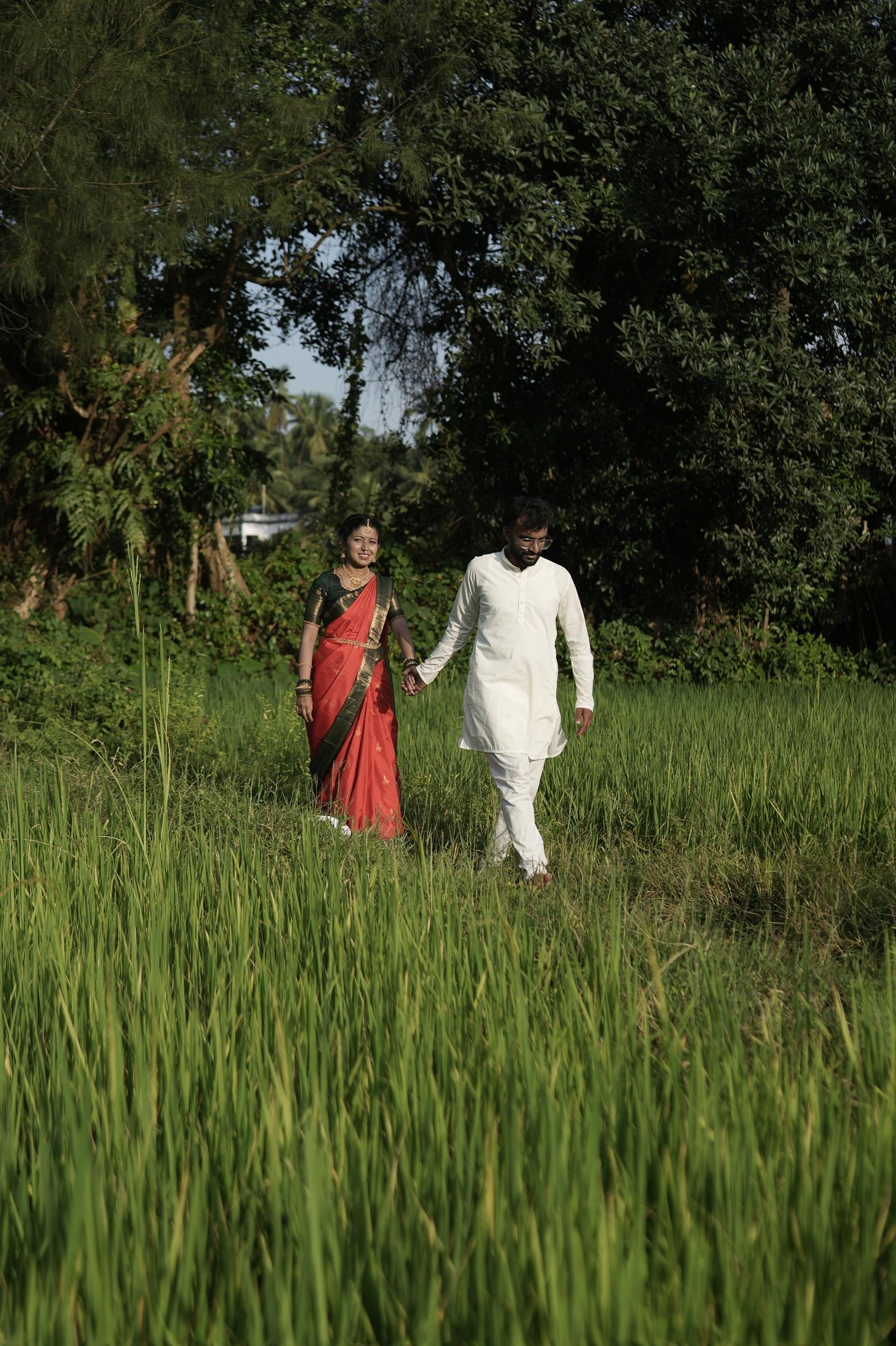 Purushotham and Nikitha walking through a green field