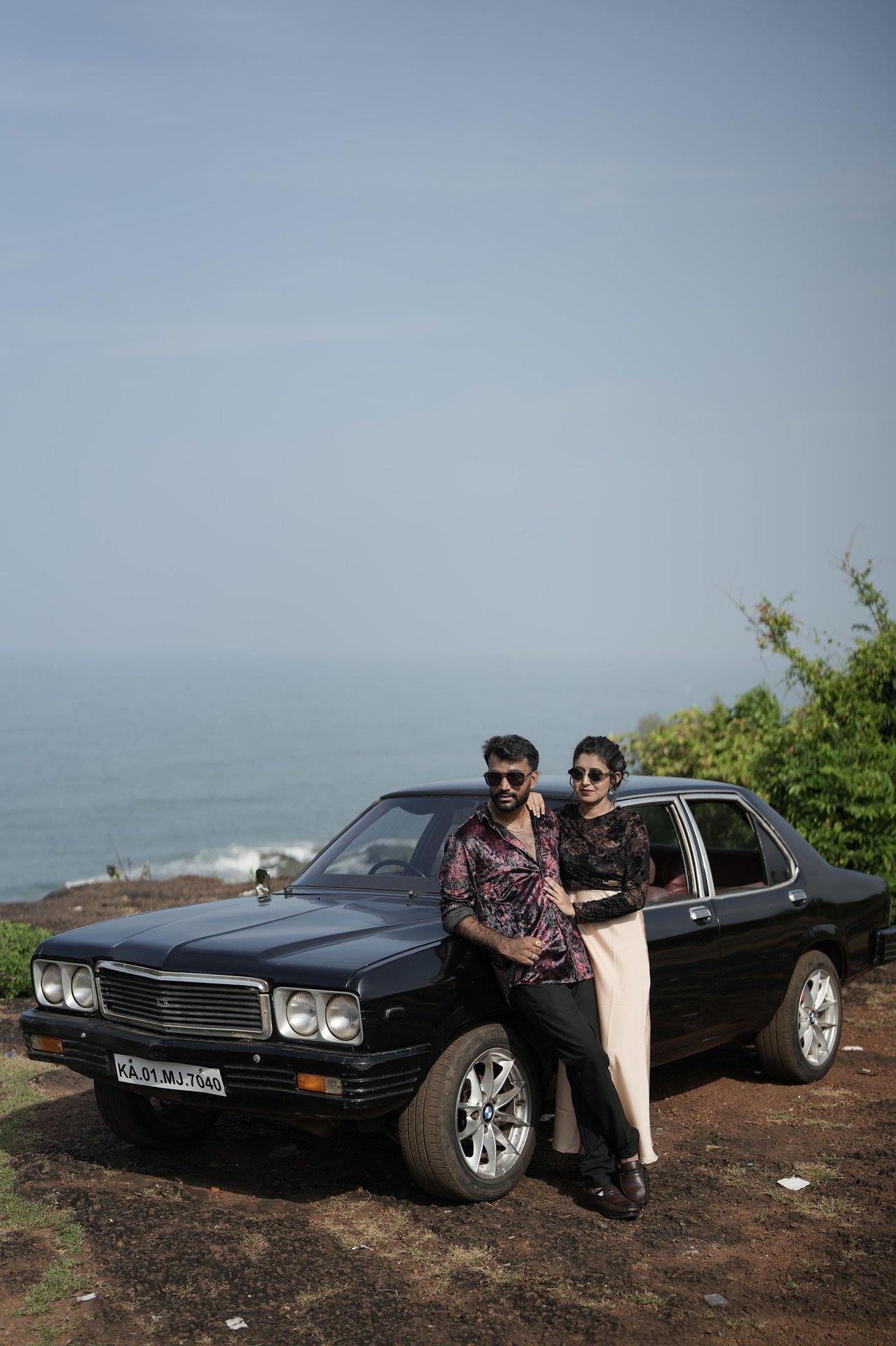 Purushotham and Nikitha with a vintage black car by the coast
