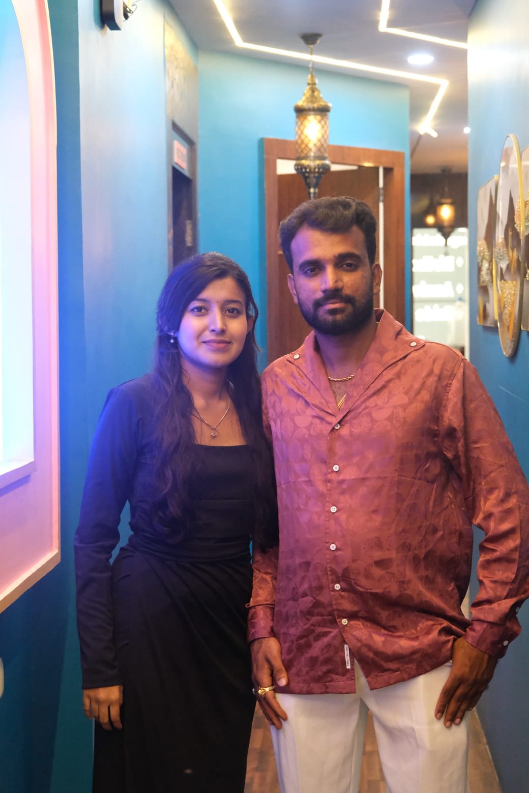 Purushotham and Nikitha smiling together indoors